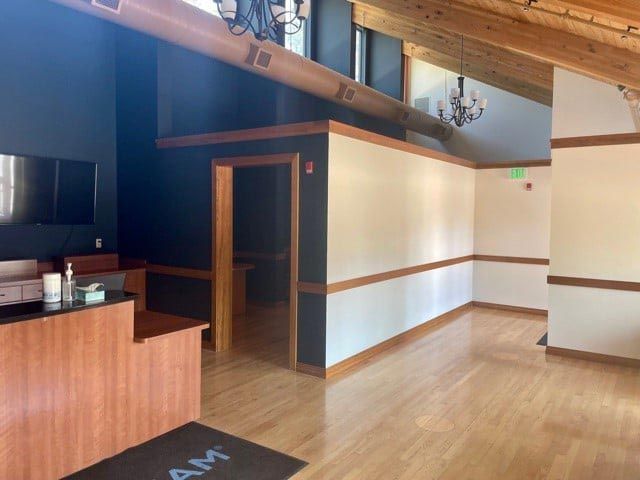 An empty room with a wooden floor and a sign that says am