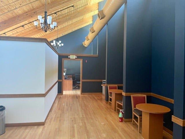 A hallway with tables and chairs and a fire extinguisher