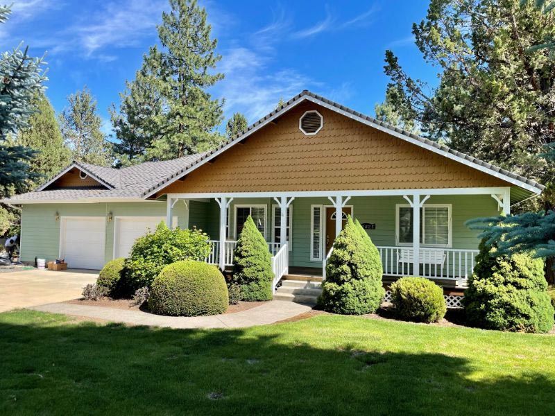 A house with a porch and trees in front of it