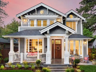 A large gray and white house with a large porch.