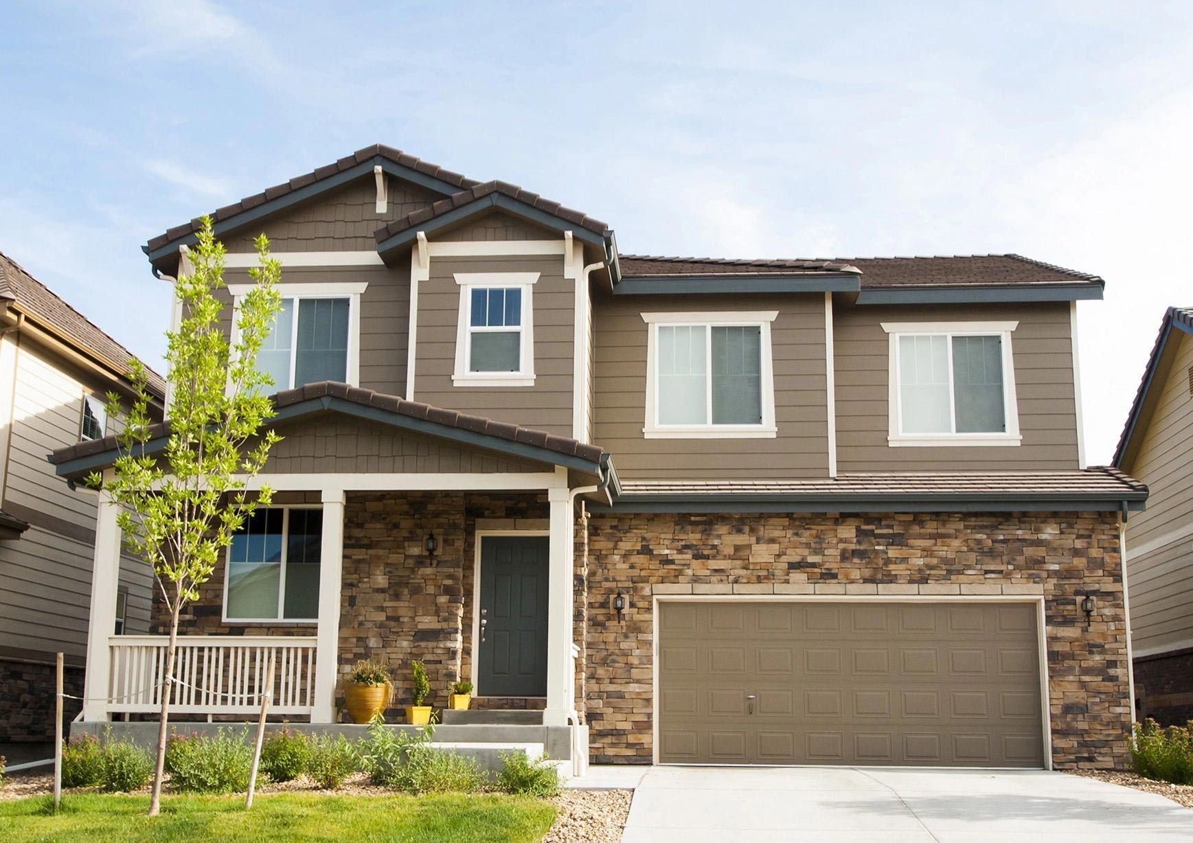 A large house with a large garage and a porch.