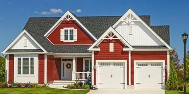 A large red and white house with two garages