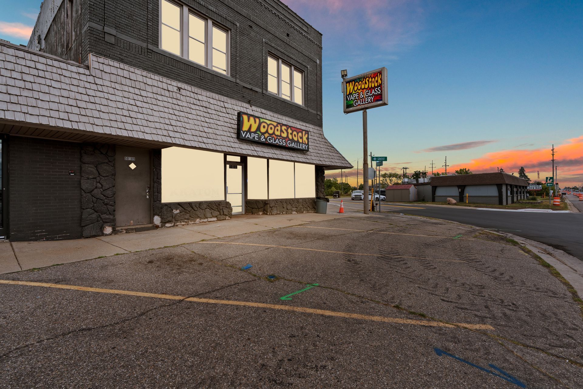 Exterior of Westside Tavern and sign, building with dark gray bricks. Dusk sky.