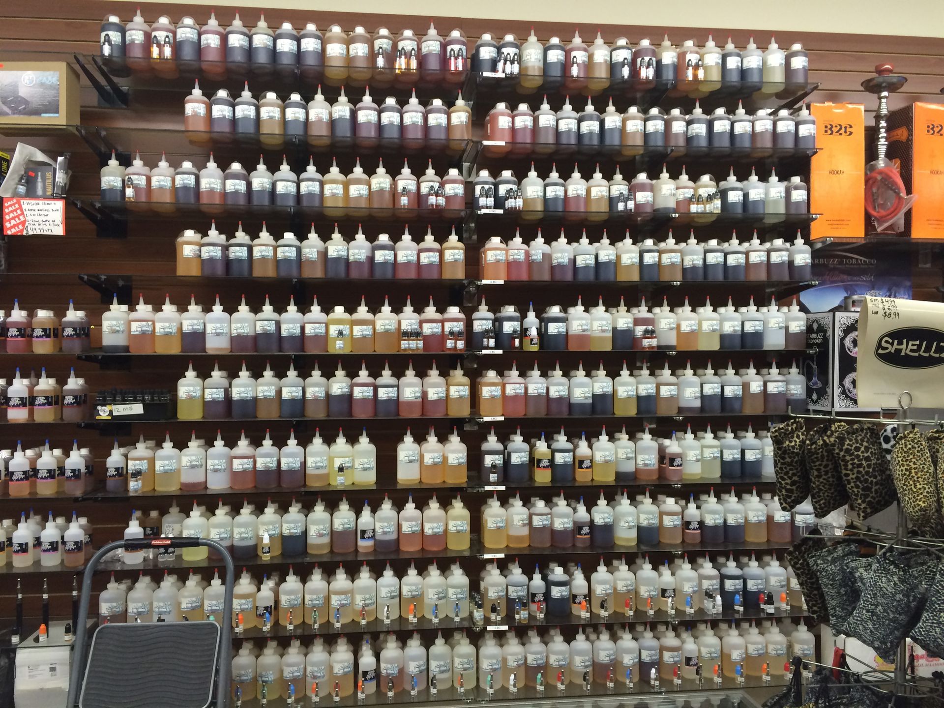 Shelves filled with various colorful bottles of e-liquids in a store.