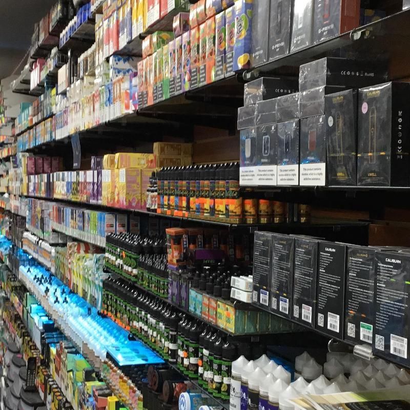 Shelves stocked with various vape products in a brightly lit store.