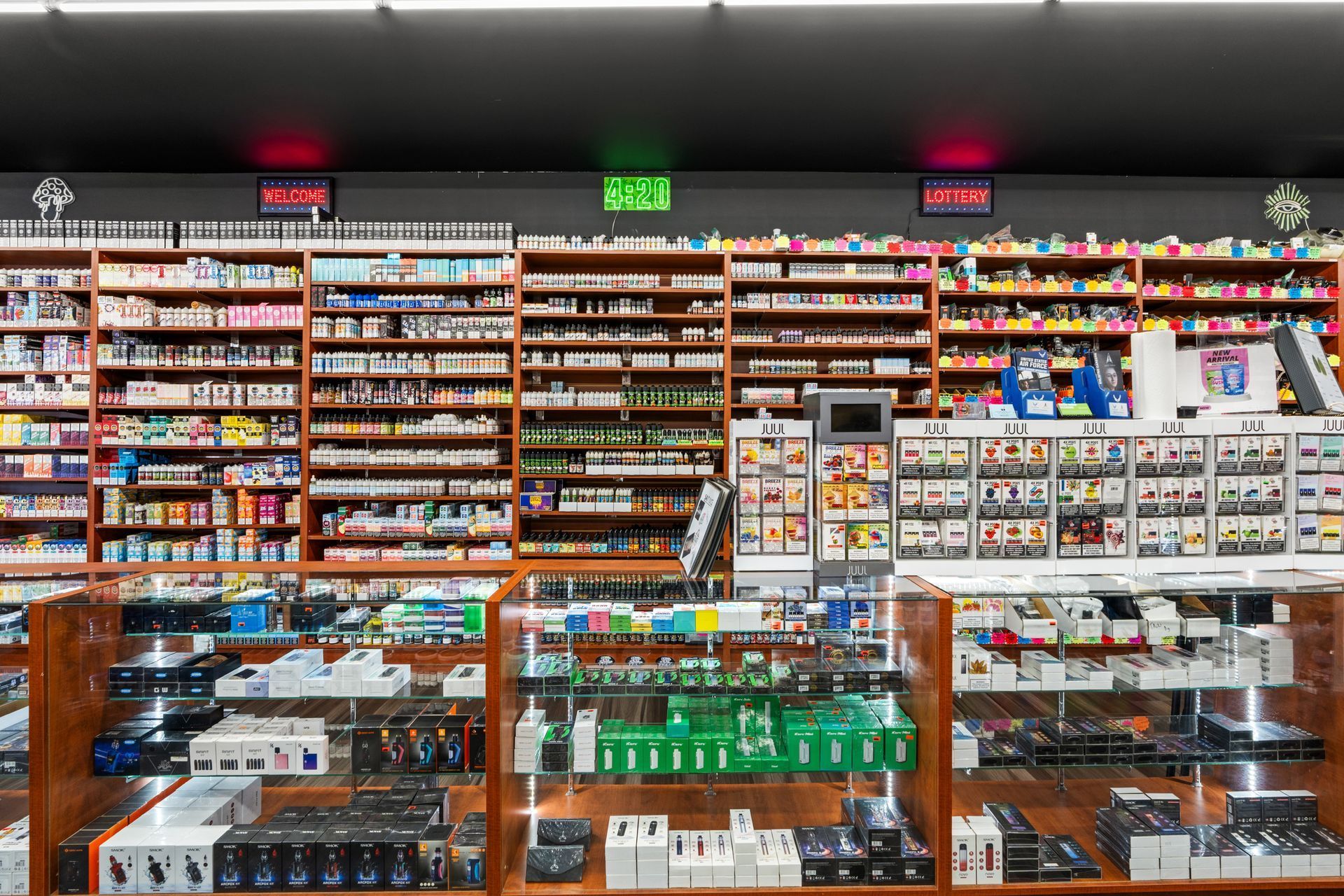 Inside of a smoke shop with shelves of products and display cases.