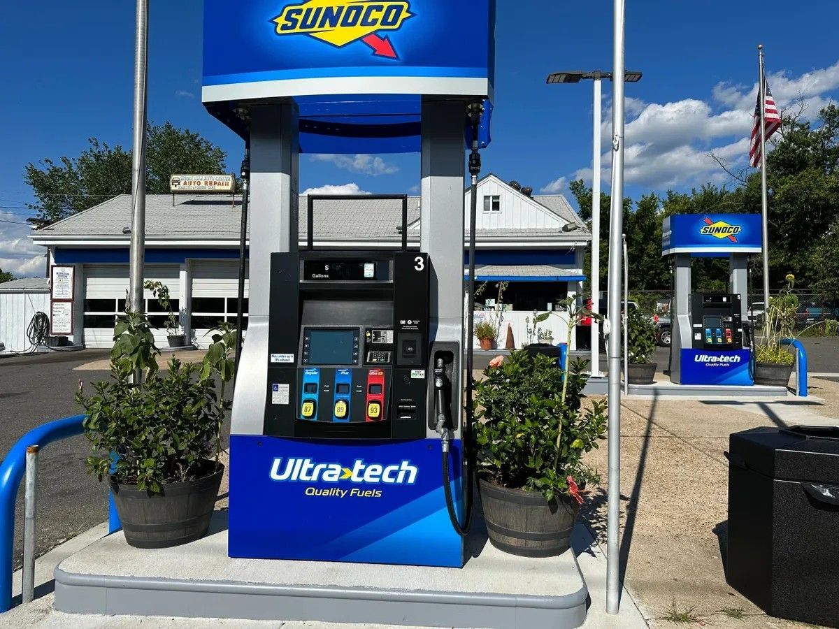 Sunoco gas station pump with blue canopy and Ultra-tech branding beside a roadside lot