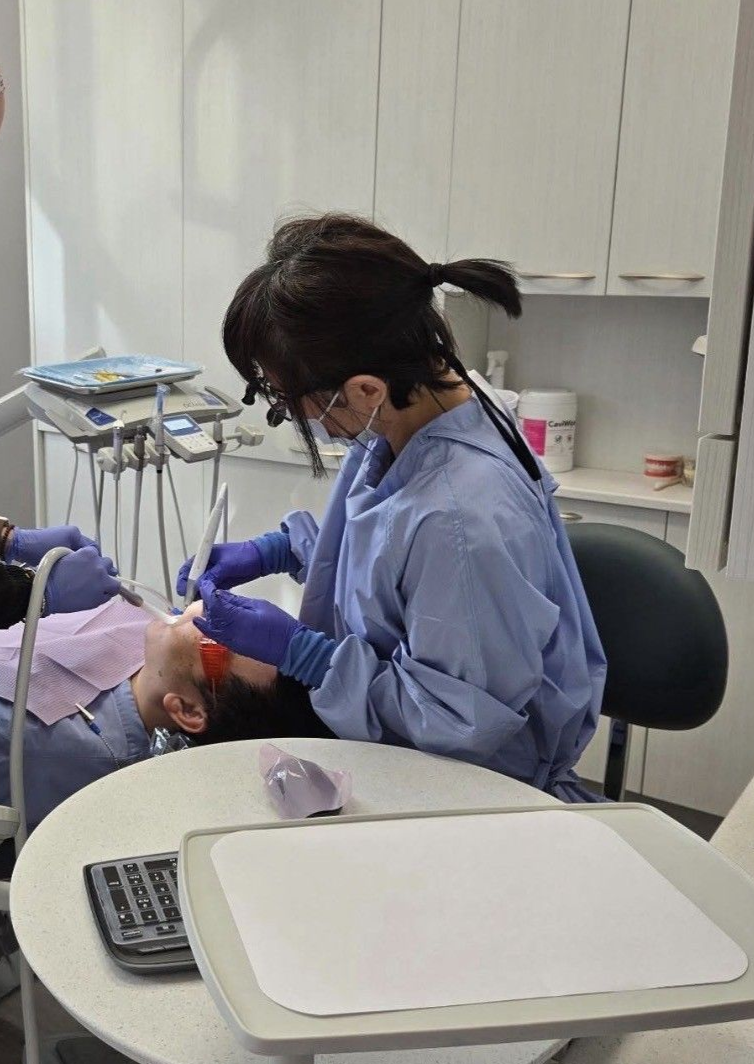 Dentist examining a patient's teeth with a mirror and probe.