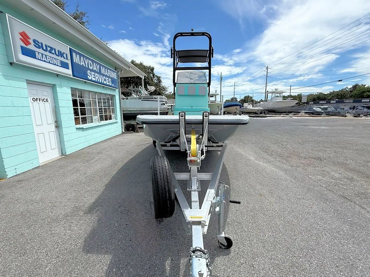 Small boat on trailer outside a marina building under a cloudy sky.