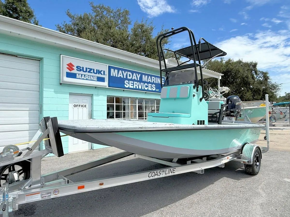 Light blue boat on a trailer outside a marina service building