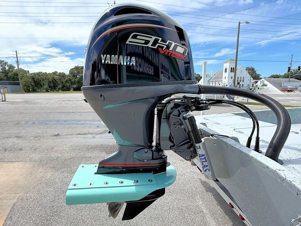Yamaha outboard motor mounted on a boat stern at a marina, with water and docks in the background