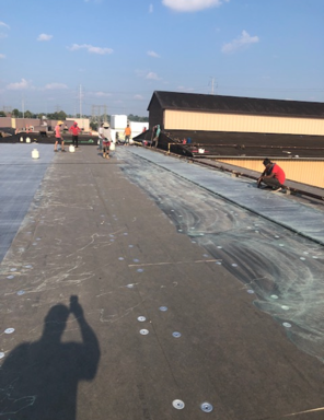 A group of people are working on the roof of a building