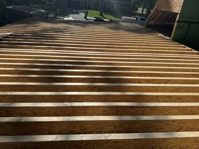 Wooden boardwalk with horizontal slats leading through a park in bright sunlight