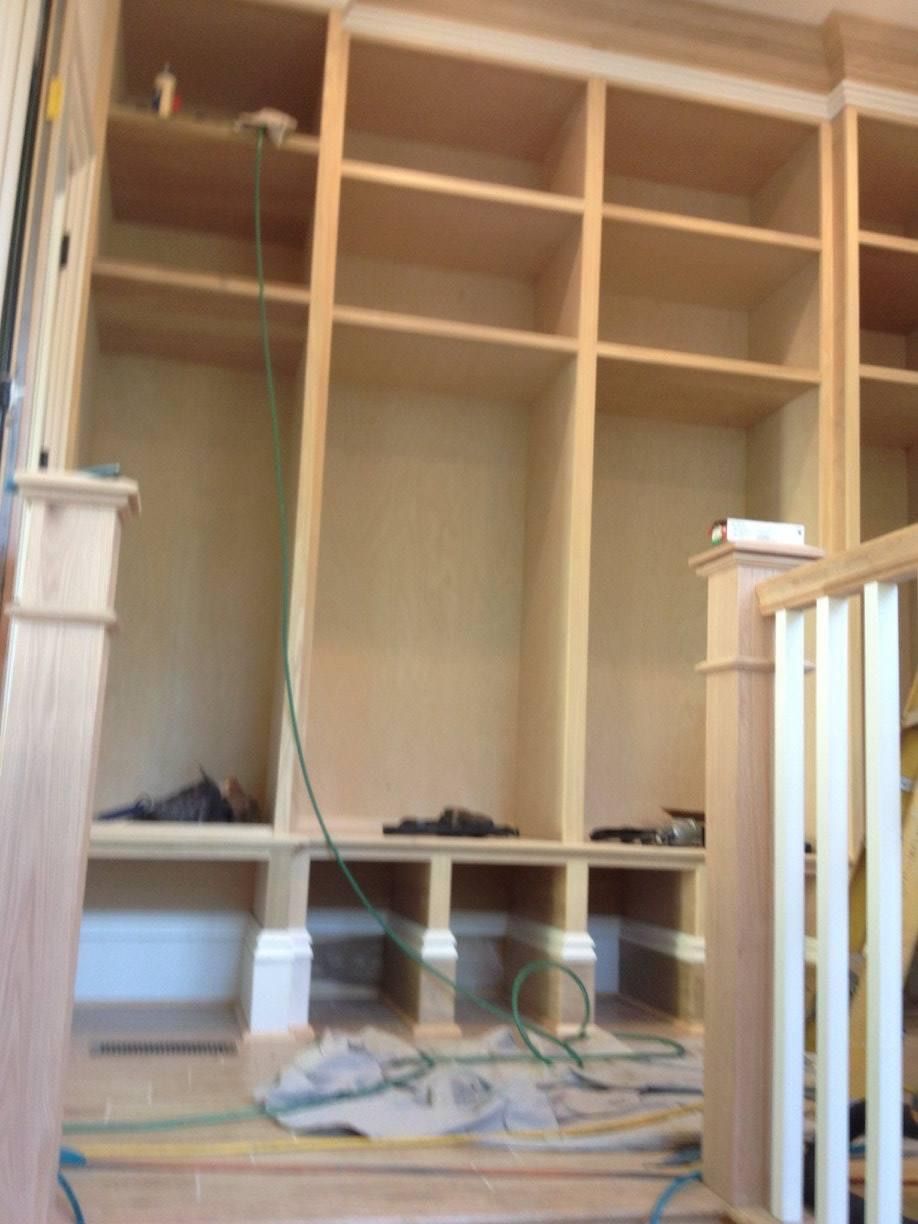 Wooden built-in bookshelves with a bench beneath; construction in progress, unfinished wood.