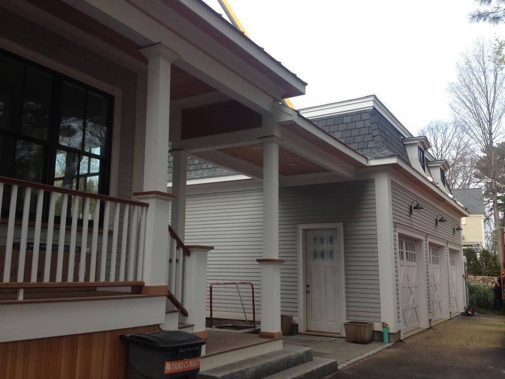 Exterior view of a house and garage with columns, porch, and a driveway.