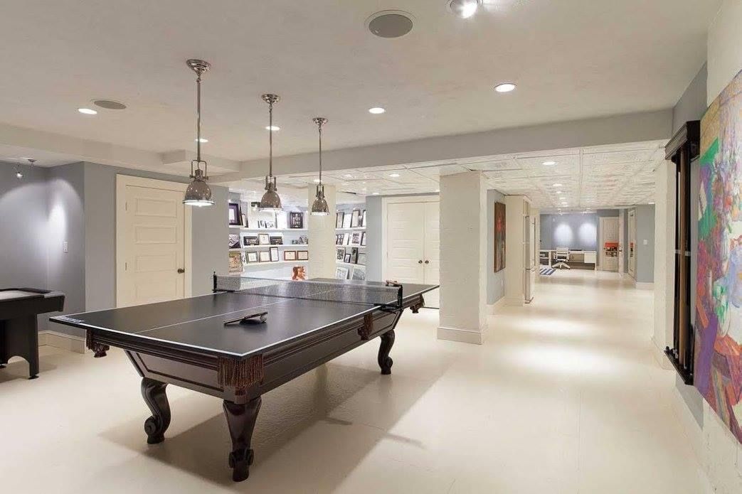 Elegant basement game room with pool table, pendant lights, and artwork.