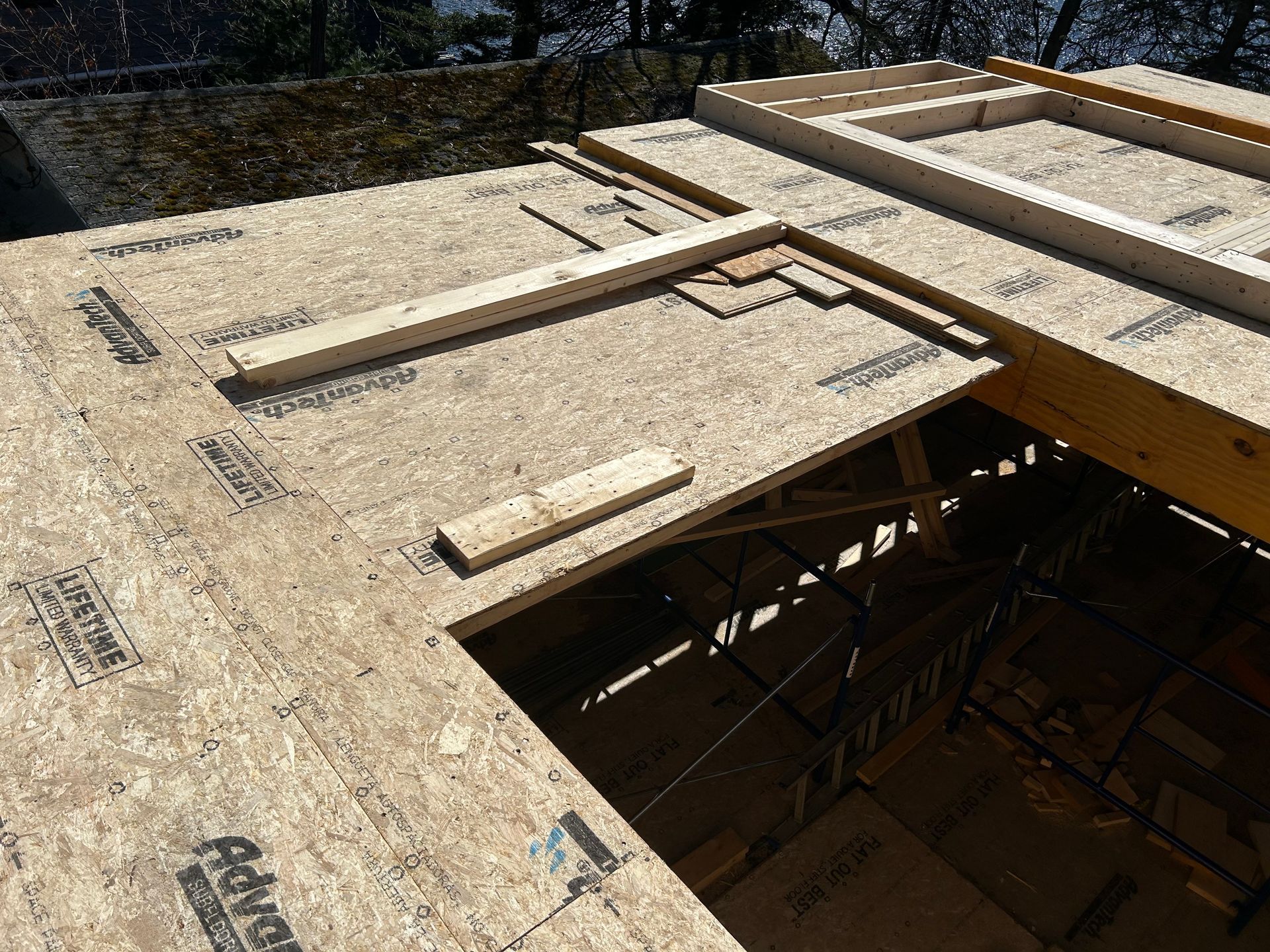 OSB sheathing and lumber framing a roof under construction.
