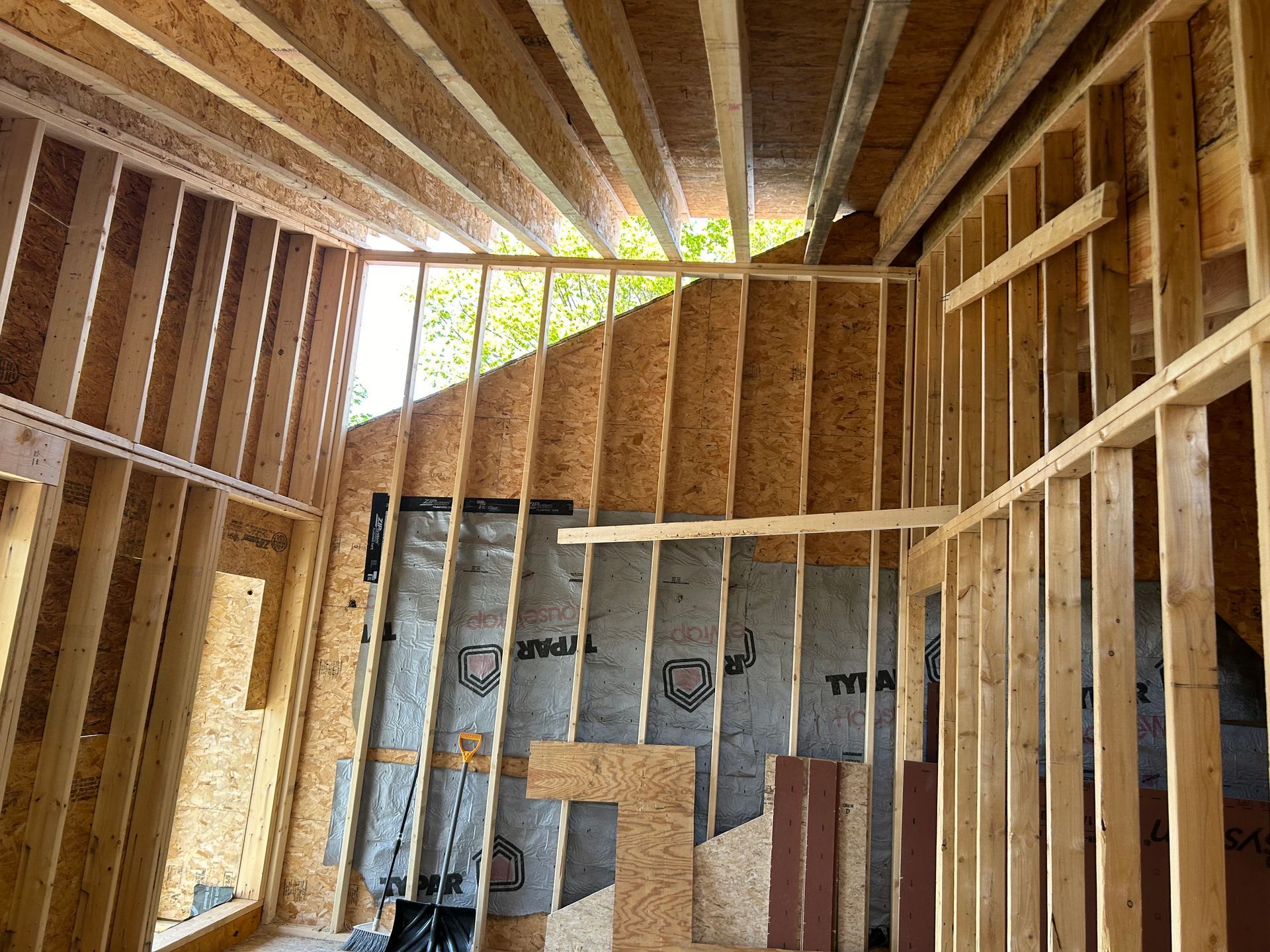 Interior wooden framing of a building under construction, with exposed beams and walls.