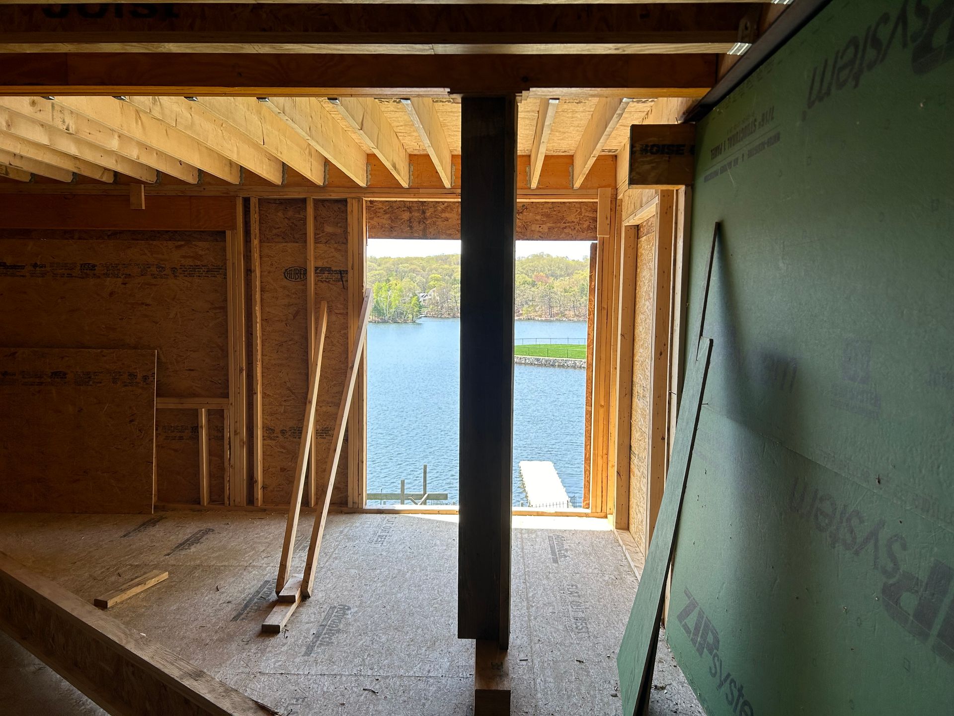 Interior of a house under construction with a lake view through the framing.