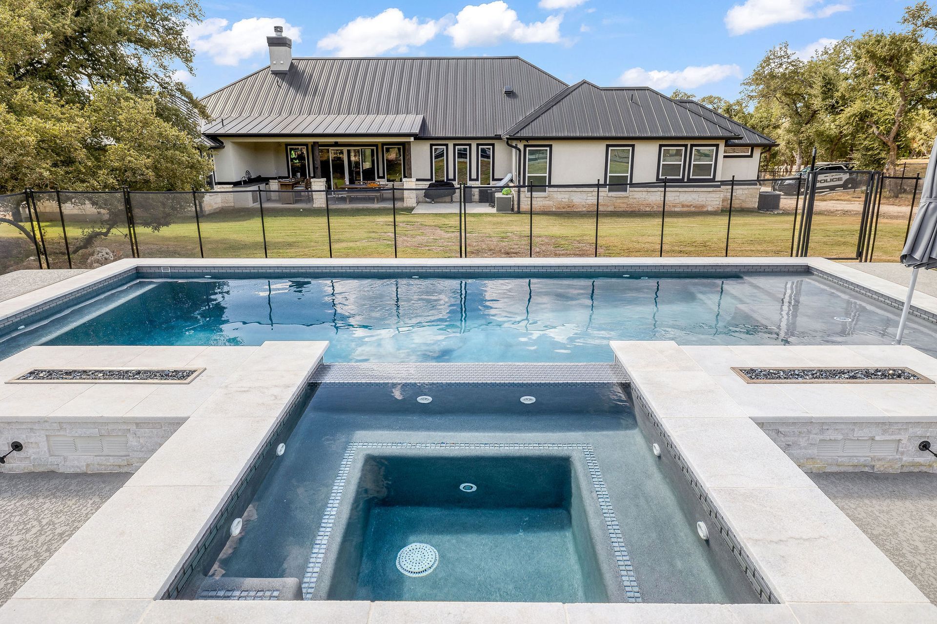 Luxury backyard pool with spa and modern house in the background