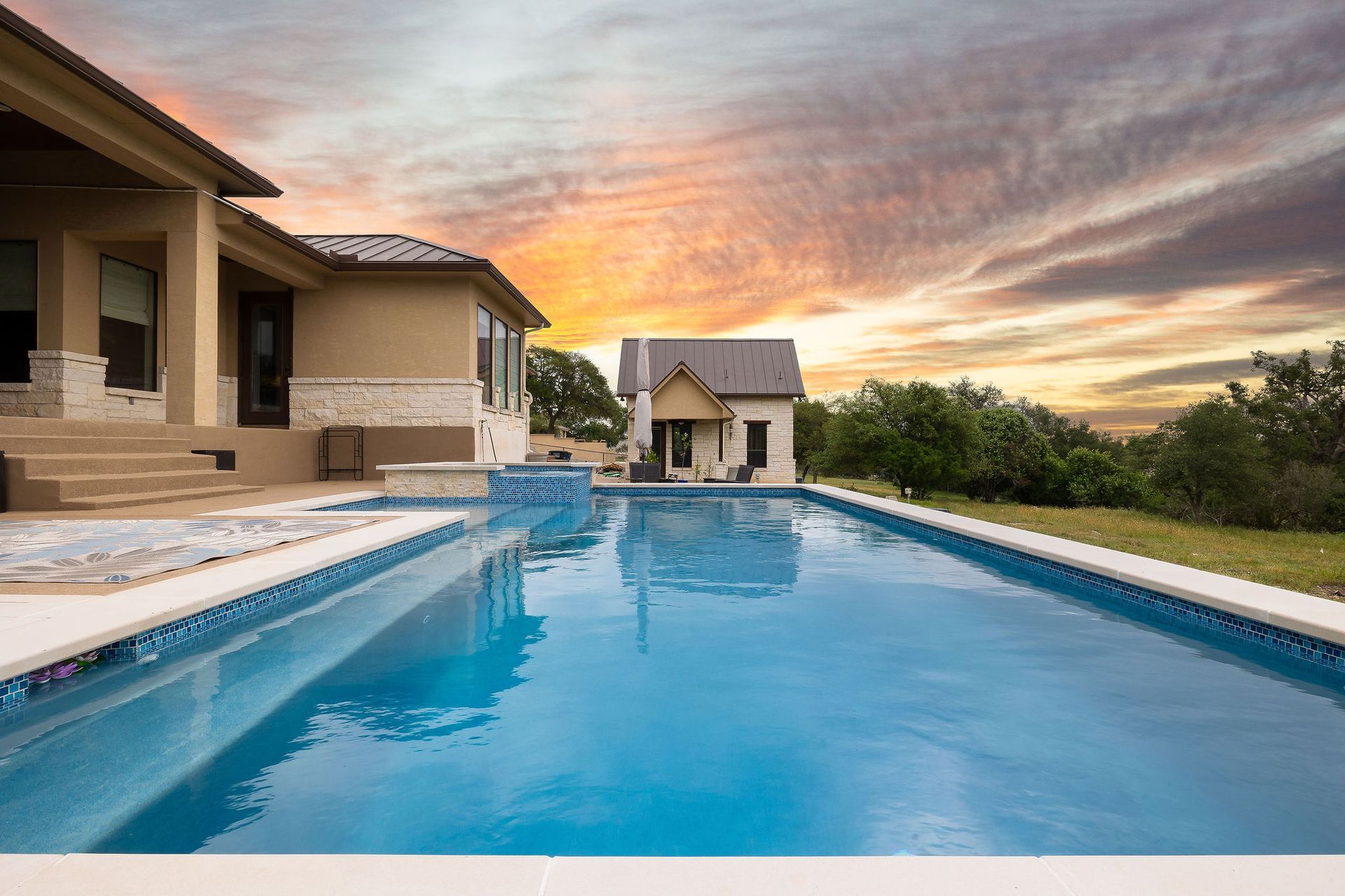 Modern house with a blue swimming pool at sunset