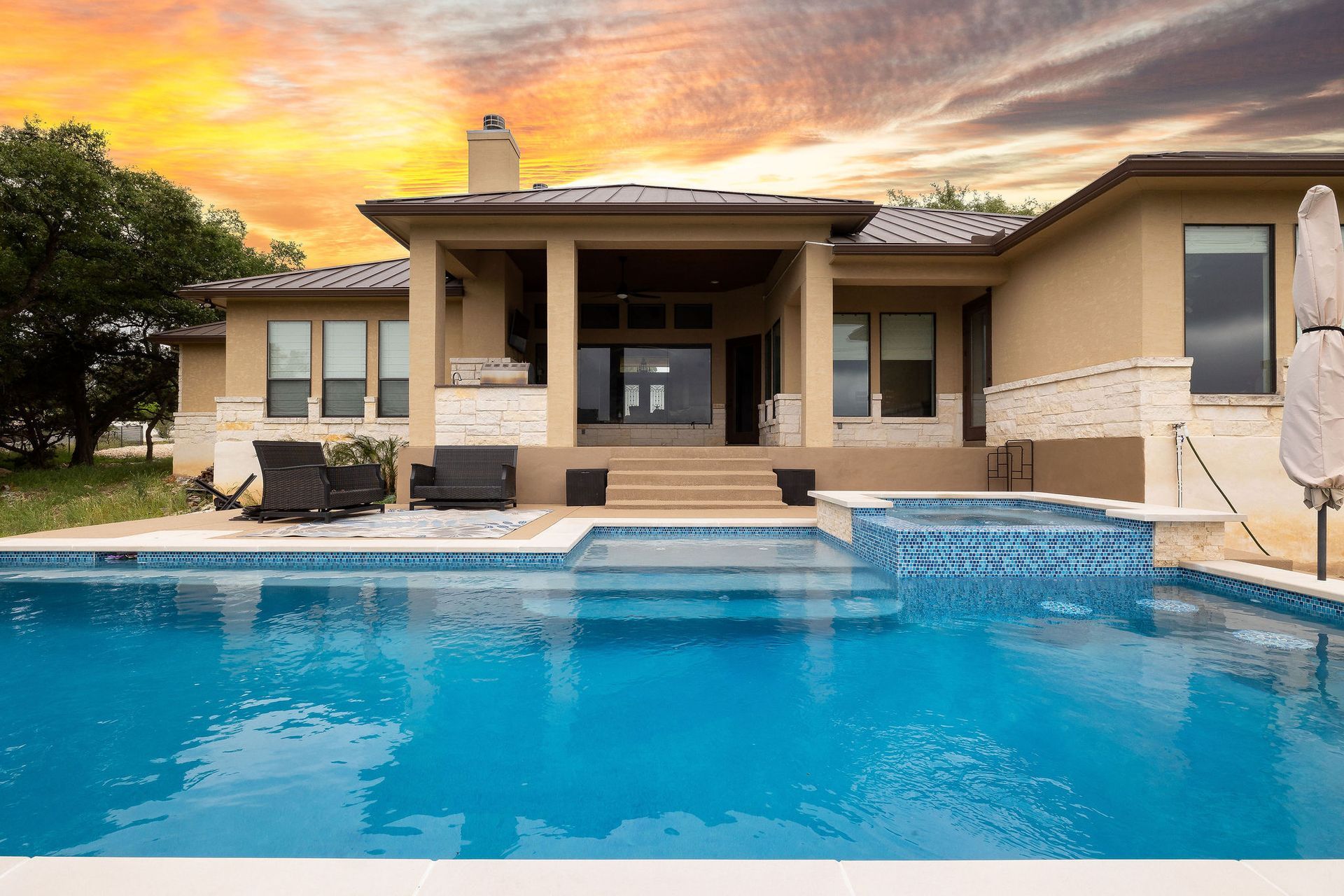 Modern house with a blue swimming pool at sunset