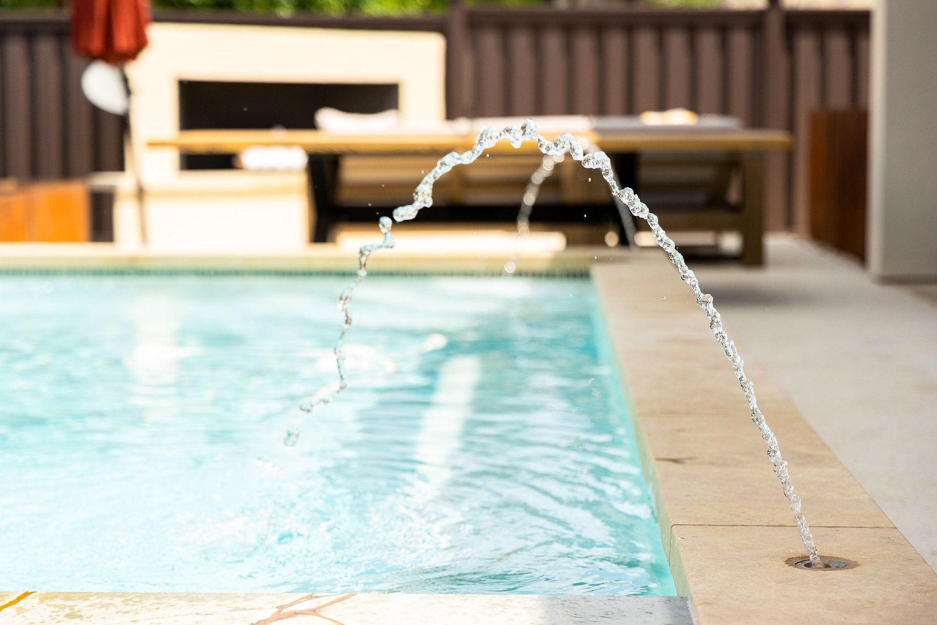 Indoor swimming pool with clear water jets arcing into the shallow end