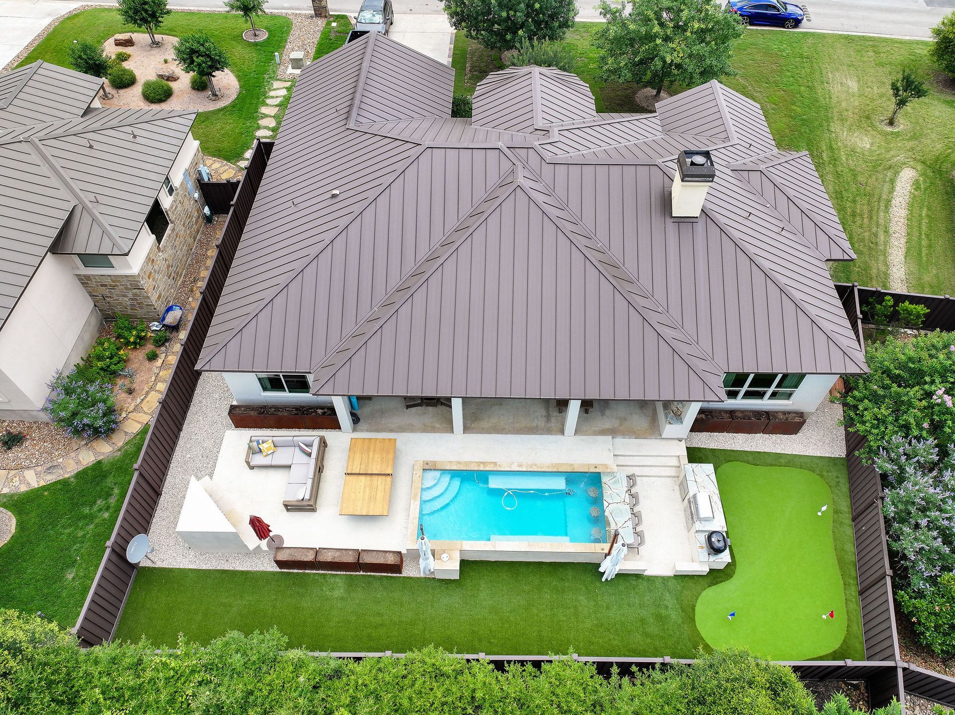 Aerial view of a house with a fenced backyard, patio, and a small swimming pool.