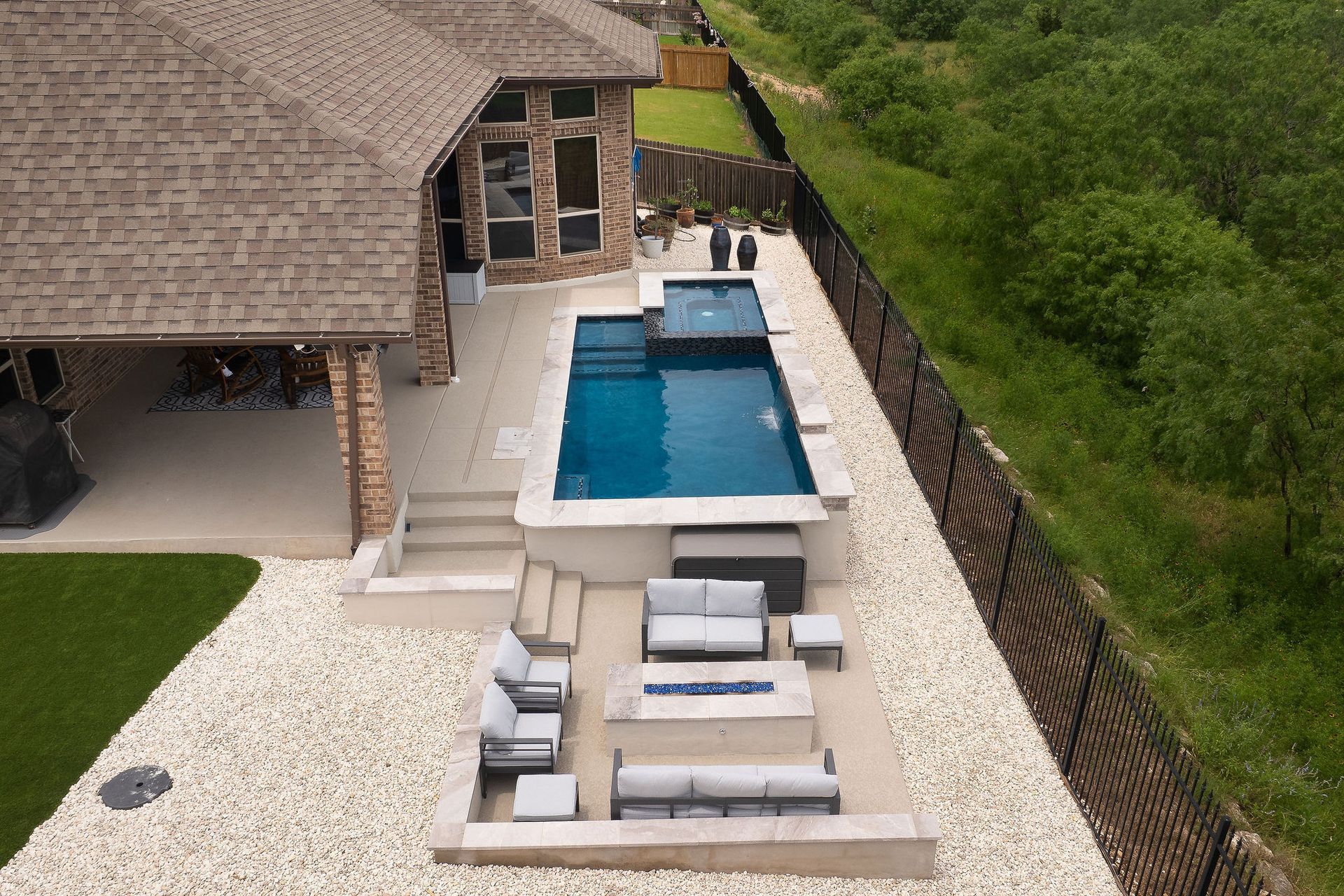 Backyard patio with a pool, lounge seating, and a covered outdoor area beside a house