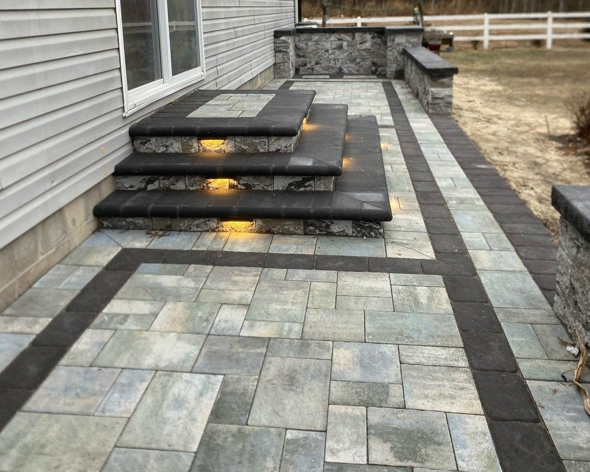 A brick walkway with stairs leading up to a house.