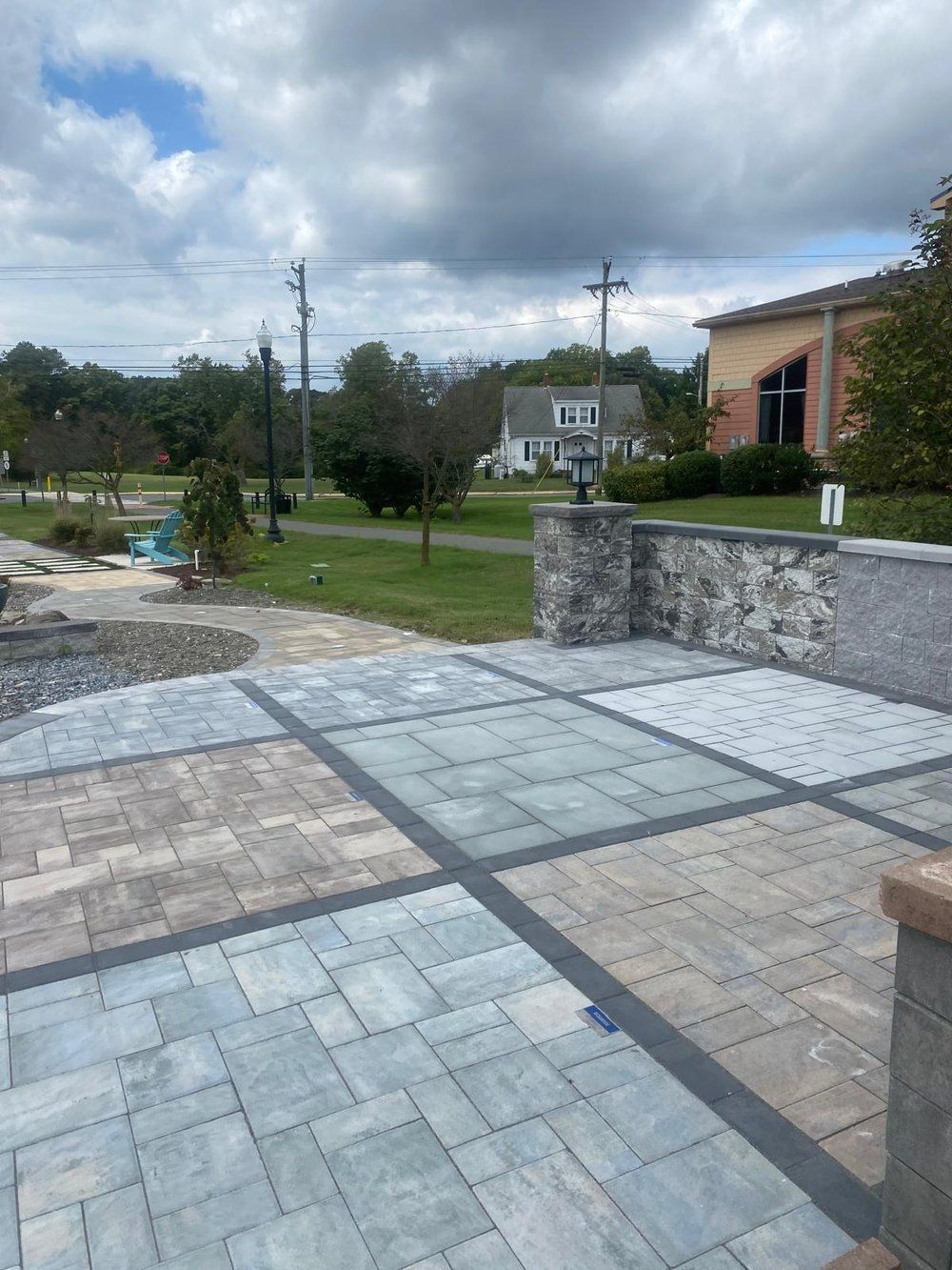 A patio with a lot of tiles and a house in the background