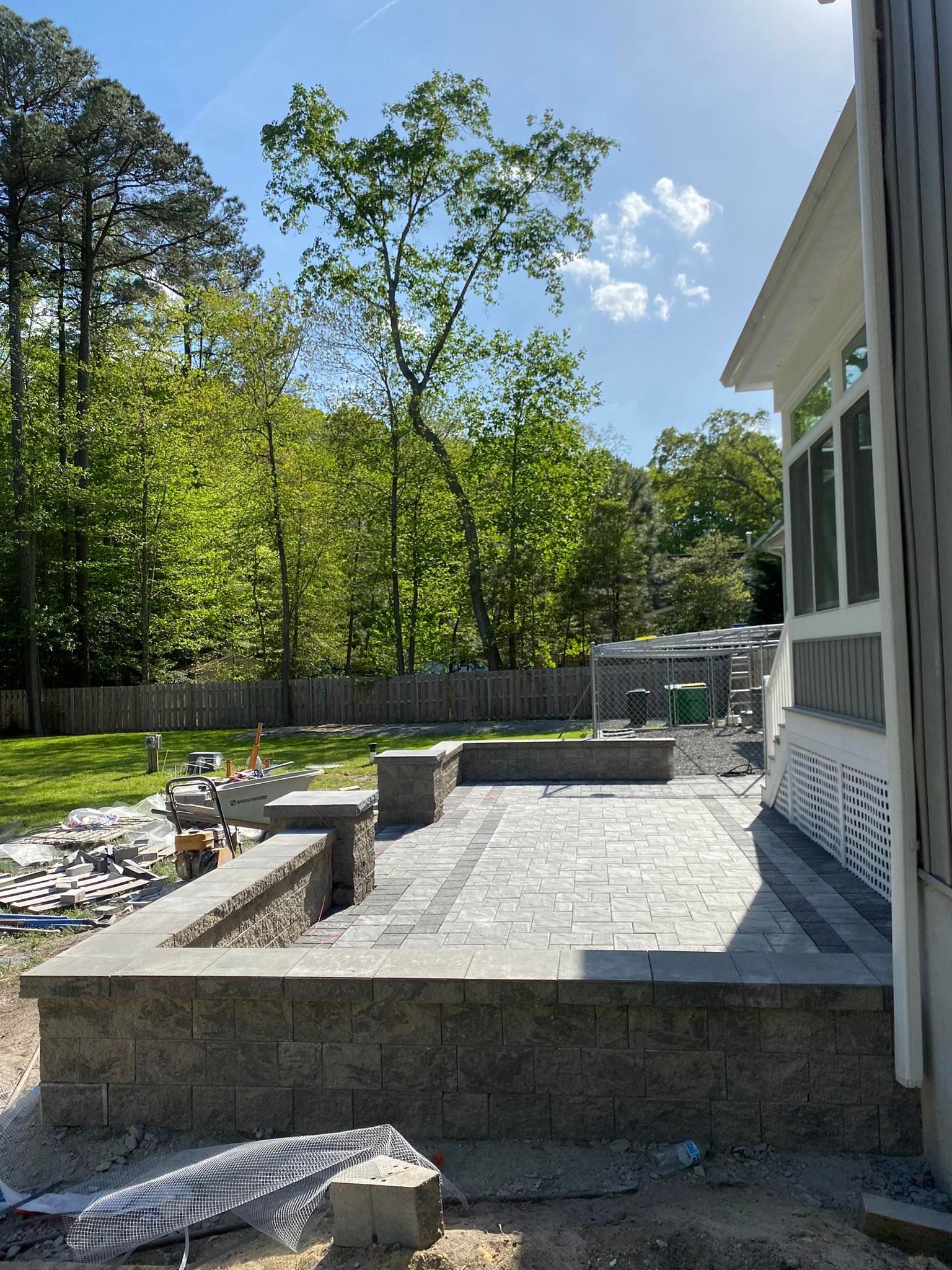 A patio is being built in the backyard of a house.