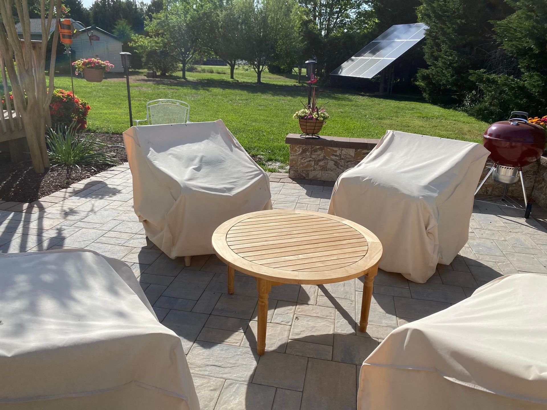 A patio with chairs and a table with covers on them