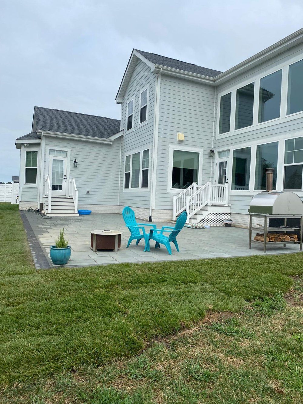 A patio with a stone wall and bricks in front of a building.