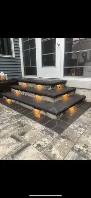 Modern outdoor front steps with built-in glowing lights leading to a house entrance