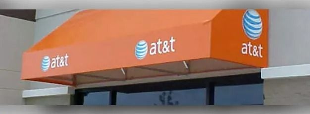 Orange AT&T awning with logos on a storefront canopy