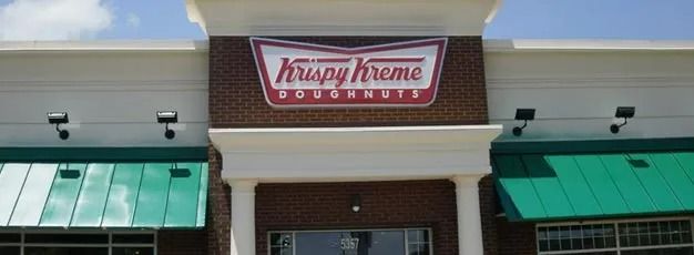 Krispy Kreme storefront with green awnings and red sign above the entrance
