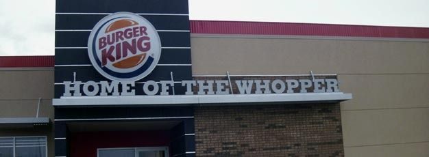 Burger King storefront sign reading “Home of the Whopper” on a brick building