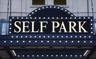 Self Park sign in white letters on a black marquee with rows of lights
