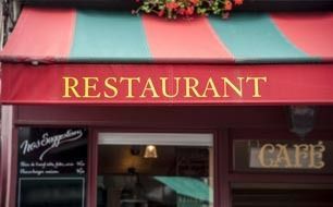 Restaurant storefront with red and green awning and gold “RESTAURANT” sign above a café entrance