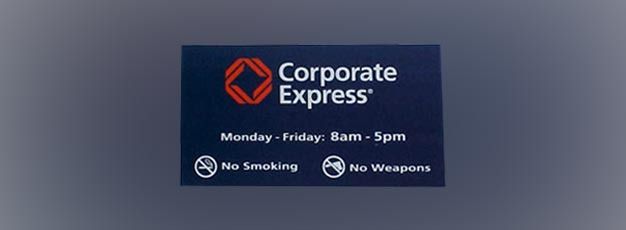 Corporate Express sign with hours and icons for no smoking and no weapons on a dark blue background