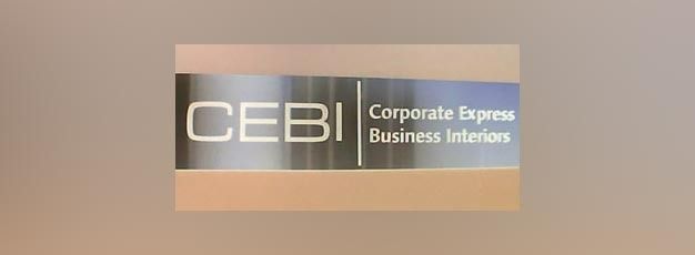 CEBI logo on a beige sign reading “Corporate Express Business Interiors”