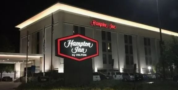 Night view of a Hampton Inn hotel with illuminated red and white signage