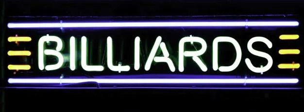 Neon Billiards sign in white letters with yellow accents on a black background