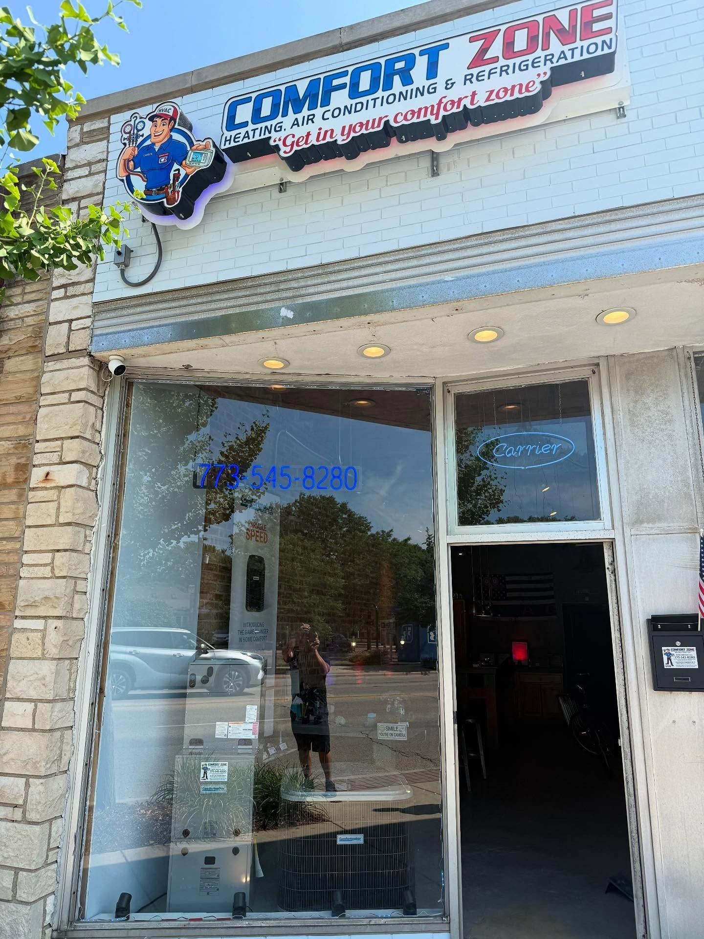 Comfort Zone HVAC store with signage and glass front.  Building with stone exterior and open doorway.