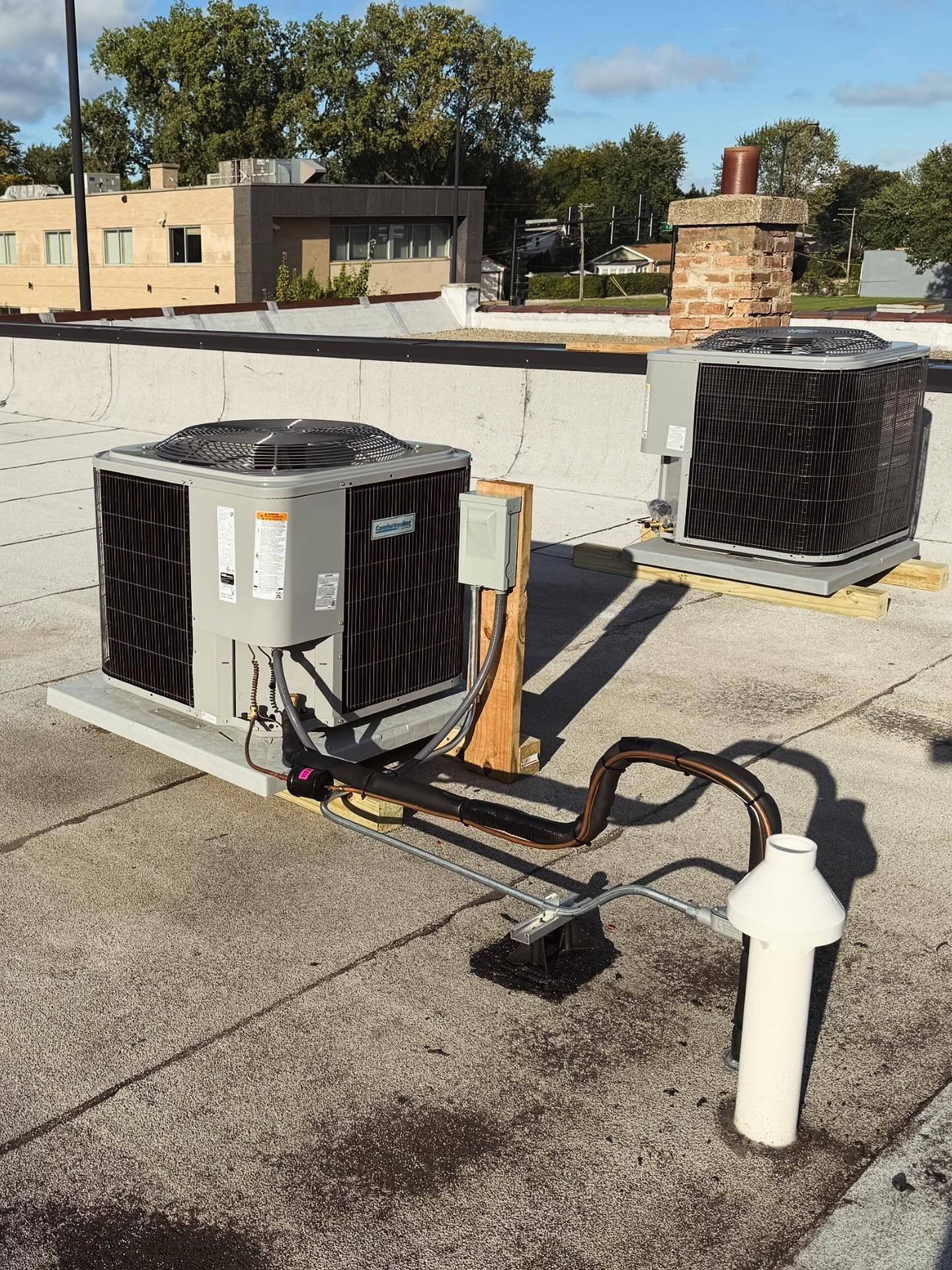Two rooftop air conditioning units on a flat roof.