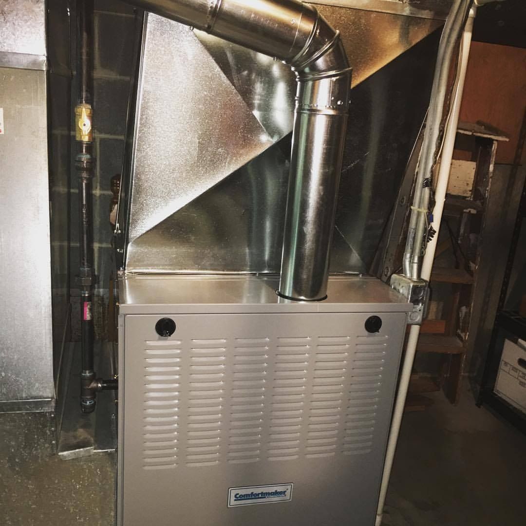 New gas furnace with metal ductwork in a basement.