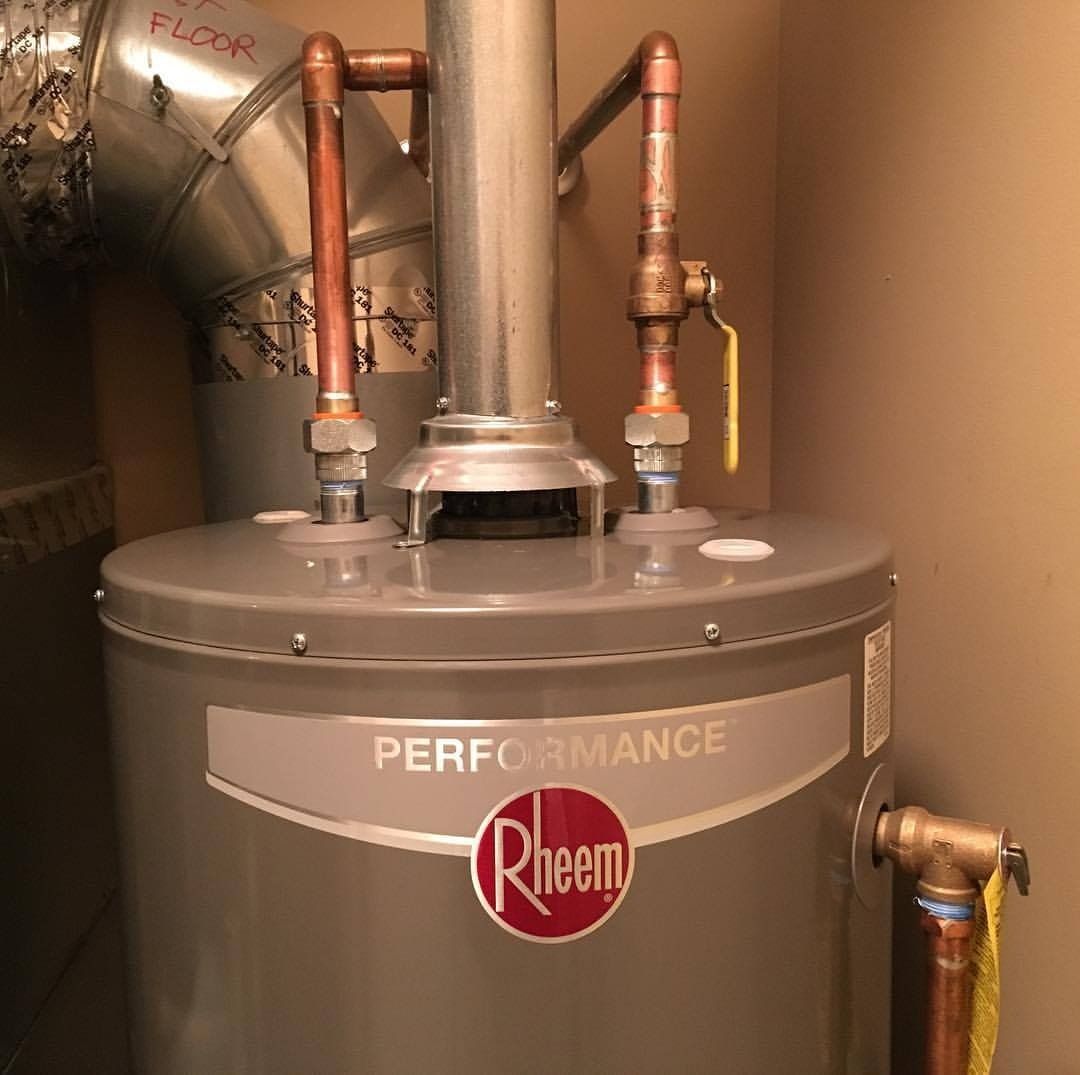 A Rheem water heater with copper pipes and a flue. Beige walls.