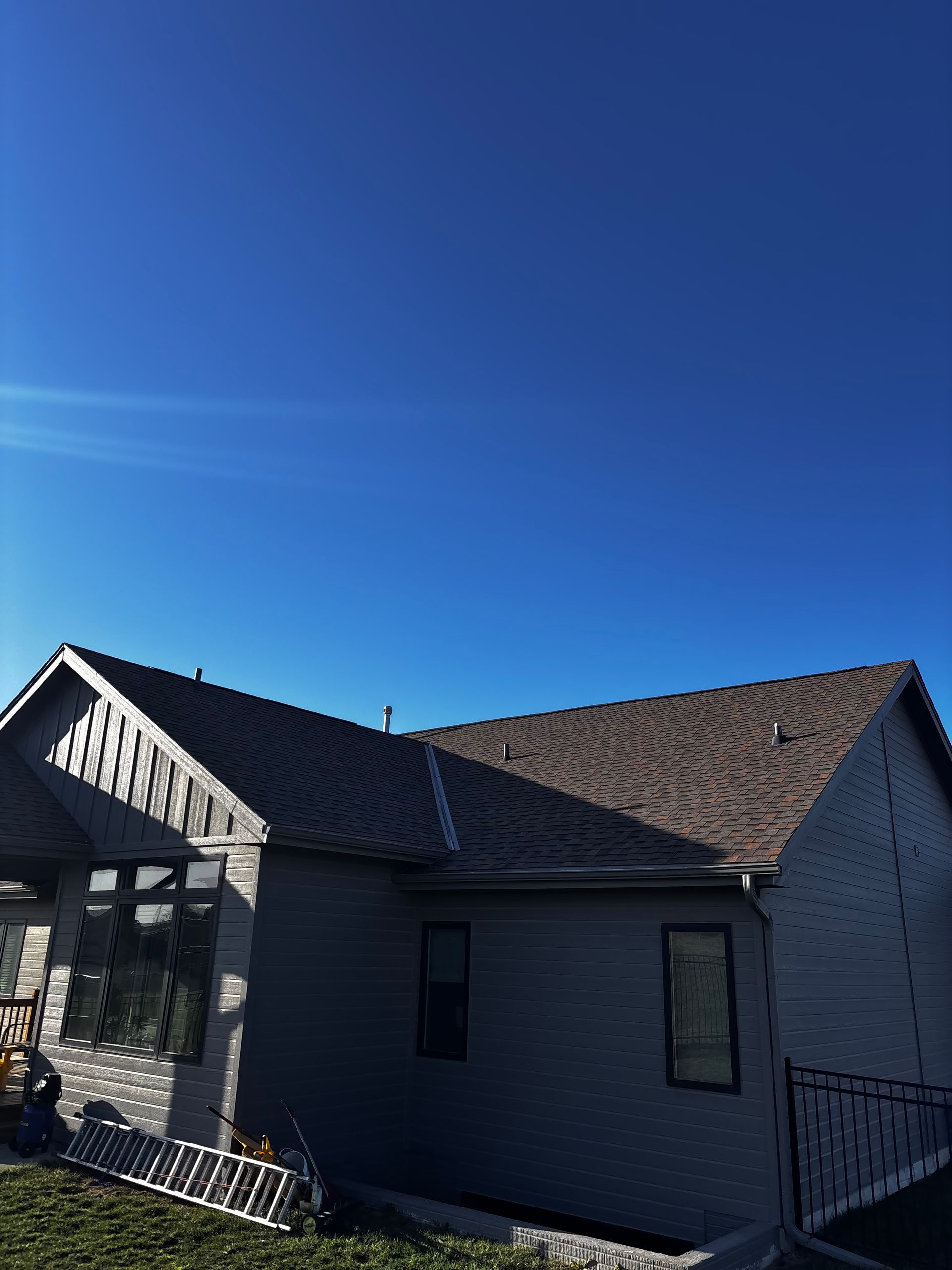 A house with a brown roof and a blue sky in the background