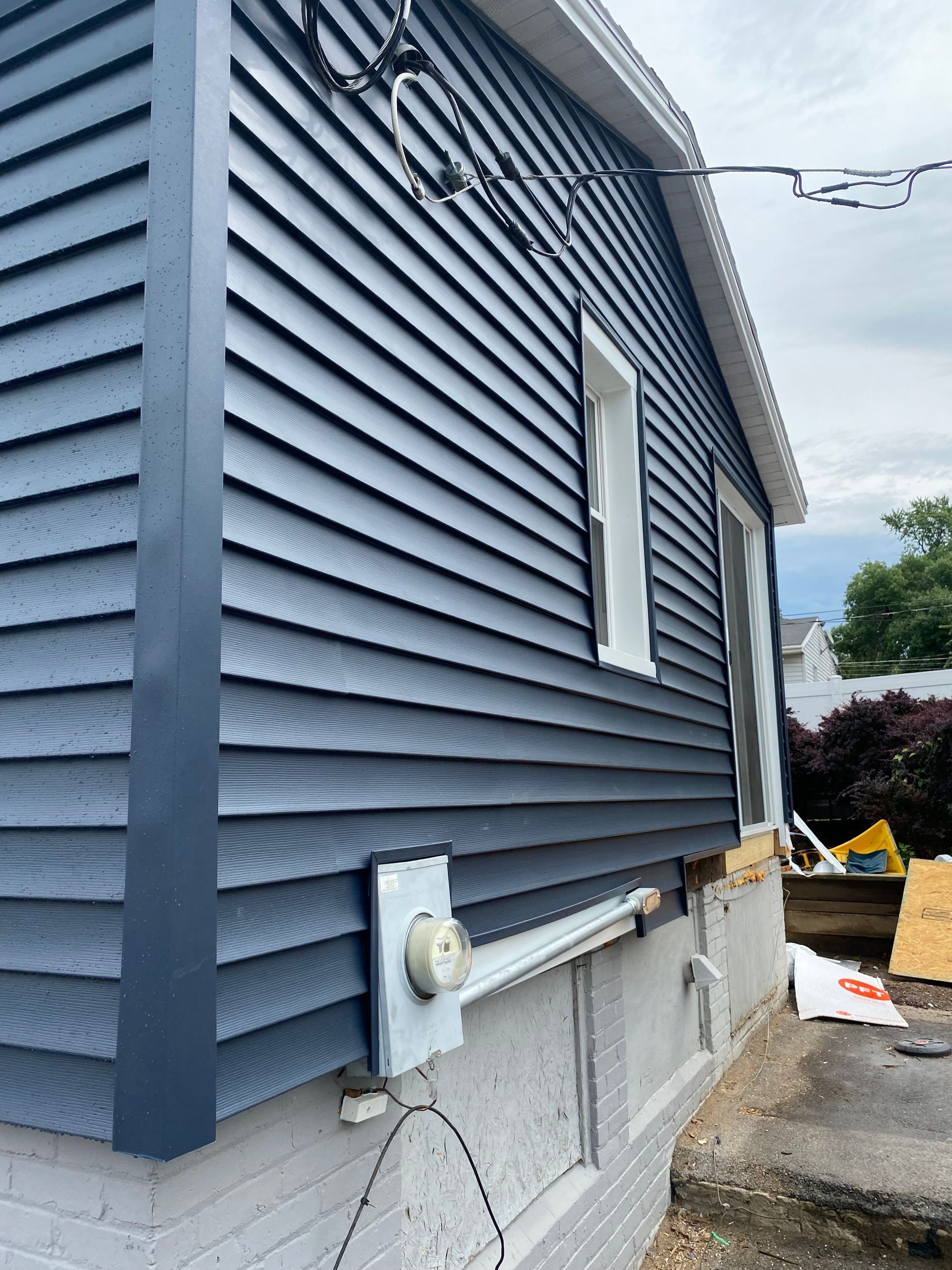 A house with a blue siding is being remodeled.